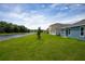 Scenic backyard view with a canal, green lawn, and neighboring homes in the distance at 2103 Forage Dr, Kissimmee, FL 34746