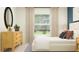 Bright bedroom with a large window and scenic views complements a modern wood dresser and a sleek, cozy style at 2103 Forage Dr, Kissimmee, FL 34746