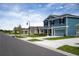 Street view of the houses with well-maintained lawns under a blue sky and wispy clouds at 2103 Forage Dr, Kissimmee, FL 34746