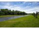 Picturesque water view of a canal bordered by a verdant green lawn and mature trees at 2103 Forage Dr, Kissimmee, FL 34746