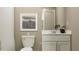 Bathroom featuring a toilet, vanity with a white sink, white cabinets, and a framed print at 2109 Forage Dr, Kissimmee, FL 34746