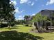 Sprawling backyard featuring lush lawn, mature trees, and partial view of the home's exterior at 2660 Wyndsor Oaks Way, Winter Haven, FL 33884