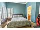 Bedroom featuring a floral-patterned bedspread, turquoise walls and natural light at 2660 Wyndsor Oaks Way, Winter Haven, FL 33884