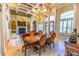 Beautiful dining room featuring travertine floors, coffered ceilings, elegant chandelier, and adjacent open concept rooms at 2660 Wyndsor Oaks Way, Winter Haven, FL 33884
