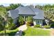 Elegant home with beautiful landscaping, vibrant green lawn, manicured bushes and decorative trees surrounding the entrance at 2660 Wyndsor Oaks Way, Winter Haven, FL 33884