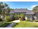 Stunning home with a manicured lawn, lush landscaping, and a grand entrance with palm trees, bushes and inviting walkway at 2660 Wyndsor Oaks Way, Winter Haven, FL 33884