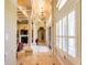 Elegant hallway featuring tile floors, stately columns, chandelier, and bright window shutters at 2660 Wyndsor Oaks Way, Winter Haven, FL 33884