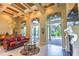 Spacious living room with fireplace and built ins, travertine flooring, tall windows to a great view of the pool at 2660 Wyndsor Oaks Way, Winter Haven, FL 33884