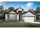 Charming single-story home featuring stone accents, a two-car garage, and manicured landscaping at 3331 Chinotto Dr, Lake Alfred, FL 33850