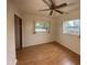 Cozy bedroom with hardwood floors, two bright windows, ceiling fan, and a neutral color scheme at 2920 Sanka Dr, Orlando, FL 32826