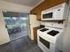 Well-lit kitchen boasting a white gas range, microwave and refrigerator with a sliding glass door to the patio at 2920 Sanka Dr, Orlando, FL 32826