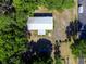 Birds eye view of a property with a metal roof, surrounded by lush greenery and trees at 6702 Brookridge Trl, Lakeland, FL 33810