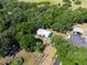 An elevated perspective of a home with metal roof amid lush trees, with a neighboring driveway at 6702 Brookridge Trl, Lakeland, FL 33810