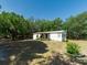 Quaint one-story home featuring a covered porch with mature trees around the home and spacious yard at 6702 Brookridge Trl, Lakeland, FL 33810