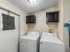 Practical laundry room with white appliances and wall-mounted cabinets, perfect for efficient chores at 6702 Brookridge Trl, Lakeland, FL 33810