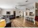 Inviting living room with wood floors, fan, and open view to the kitchen with a breakfast bar at 6702 Brookridge Trl, Lakeland, FL 33810
