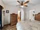 Charming bedroom with wood-look floors, a ceiling fan, and access to an ensuite bathroom at 6702 Brookridge Trl, Lakeland, FL 33810