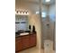 Bathroom featuring tiled walk-in shower, granite vanity, and modern vanity lighting at 1415 Colonial Ct, Winter Haven, FL 33884