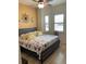 Bedroom featuring a queen-sized bed with floral bedding, and plantation shutters allowing natural light at 1415 Colonial Ct, Winter Haven, FL 33884