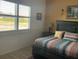 Cozy bedroom showcasing a comfortable bed with striped bedding and natural light from window at 1415 Colonial Ct, Winter Haven, FL 33884