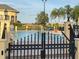 Community pool surrounded by lush landscaping and secure fencing at 1415 Colonial Ct, Winter Haven, FL 33884