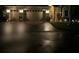 Night view of a home with a well-lit driveway and a three-car garage at 1415 Colonial Ct, Winter Haven, FL 33884