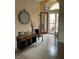 Inviting foyer with neutral tile floors, decorative console table and striking front door and transom window at 1415 Colonial Ct, Winter Haven, FL 33884