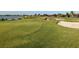 Lush green golf course with sand trap and distant water views, perfect for a relaxing round of golf at 1415 Colonial Ct, Winter Haven, FL 33884