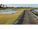 Picturesque golf course showcasing a wooden bridge, calm water feature, and homes in the distance at 1415 Colonial Ct, Winter Haven, FL 33884