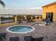 Outdoor hot tubs on brick patio offer serene lake views and comfortable seating for relaxing and entertaining at 1415 Colonial Ct, Winter Haven, FL 33884