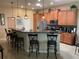 Spacious kitchen featuring a large island with a breakfast bar, dark countertops, and wooden cabinets at 1415 Colonial Ct, Winter Haven, FL 33884