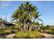 Beautifully landscaped roundabout featuring lush palm trees, trimmed bushes, and manicured brick pavers at 1415 Colonial Ct, Winter Haven, FL 33884