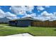This backyard features a well-maintained lawn, a screened in porch, and wooden fencing at 8804 Harrison Rd, Lakeland, FL 33810