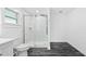 Contemporary bathroom showcasing a glass shower, white toilet and modern flooring at 8804 Harrison Rd, Lakeland, FL 33810