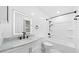Bathroom featuring black hardware, modern vanity with illuminated mirror, and white marble floors at 8804 Harrison Rd, Lakeland, FL 33810