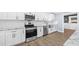Bright kitchen with stainless steel appliances, white cabinets, stone countertops and wooden floors at 8804 Harrison Rd, Lakeland, FL 33810