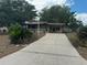 Charming single-story home with a long driveway, carport, and well-maintained landscaping at 11407 Bobwhite Blvd, Leesburg, FL 34788
