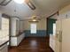 Eat-in kitchen with white cabinets, laminate countertops, ceiling fan, and hardwood floors at 11407 Bobwhite Blvd, Leesburg, FL 34788