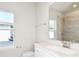 Bathroom with a vanity, modern faucet, and a tiled shower under natural light at 1403 Hamilton Way, Lake Alfred, FL 33850