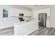 Well-lit kitchen featuring white cabinetry, stainless steel appliances, and a center island at 1403 Hamilton Way, Lake Alfred, FL 33850