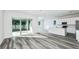 Open-concept living room featuring sliding glass doors and durable hardwood floors throughout at 1403 Hamilton Way, Lake Alfred, FL 33850