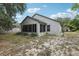 Exterior back view showing well-maintained stucco and a tidy outdoor area at 30653 Pga Dr, Sorrento, FL 32776
