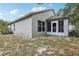 Exterior of home with a screened-in patio and a mix of grass and landscaping in the backyard at 30653 Pga Dr, Sorrento, FL 32776