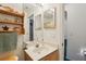 Bathroom vanity with wooden cabinet, neutral countertop, decorative shelving and double mirrors at 30653 Pga Dr, Sorrento, FL 32776