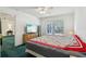 Bright bedroom with a large window and a TV over a wooden dresser at 30653 Pga Dr, Sorrento, FL 32776