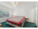 This cozy bedroom features a bright ceiling fan, large window, and a colorful quilt at 30653 Pga Dr, Sorrento, FL 32776