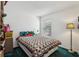 Cozy bedroom with green carpet, a bed with a colorful quilt, and a window with blinds at 30653 Pga Dr, Sorrento, FL 32776