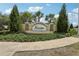 Community entrance sign surrounded by lush greenery and manicured landscaping at 30653 Pga Dr, Sorrento, FL 32776