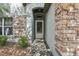 Close up of the front door with brick accents and stone cladding at 30653 Pga Dr, Sorrento, FL 32776