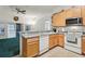 Efficient kitchen with light wood cabinets, a dishwasher, and smooth cooktop for easy meal preparation and cleanup at 30653 Pga Dr, Sorrento, FL 32776